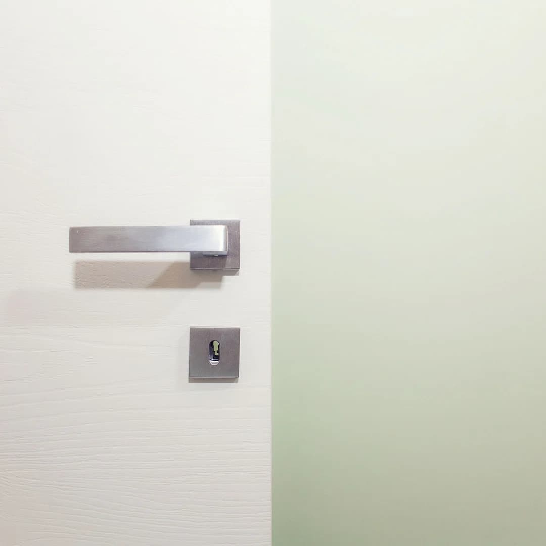 Dettaglio della porta interna bianca e della maniglia