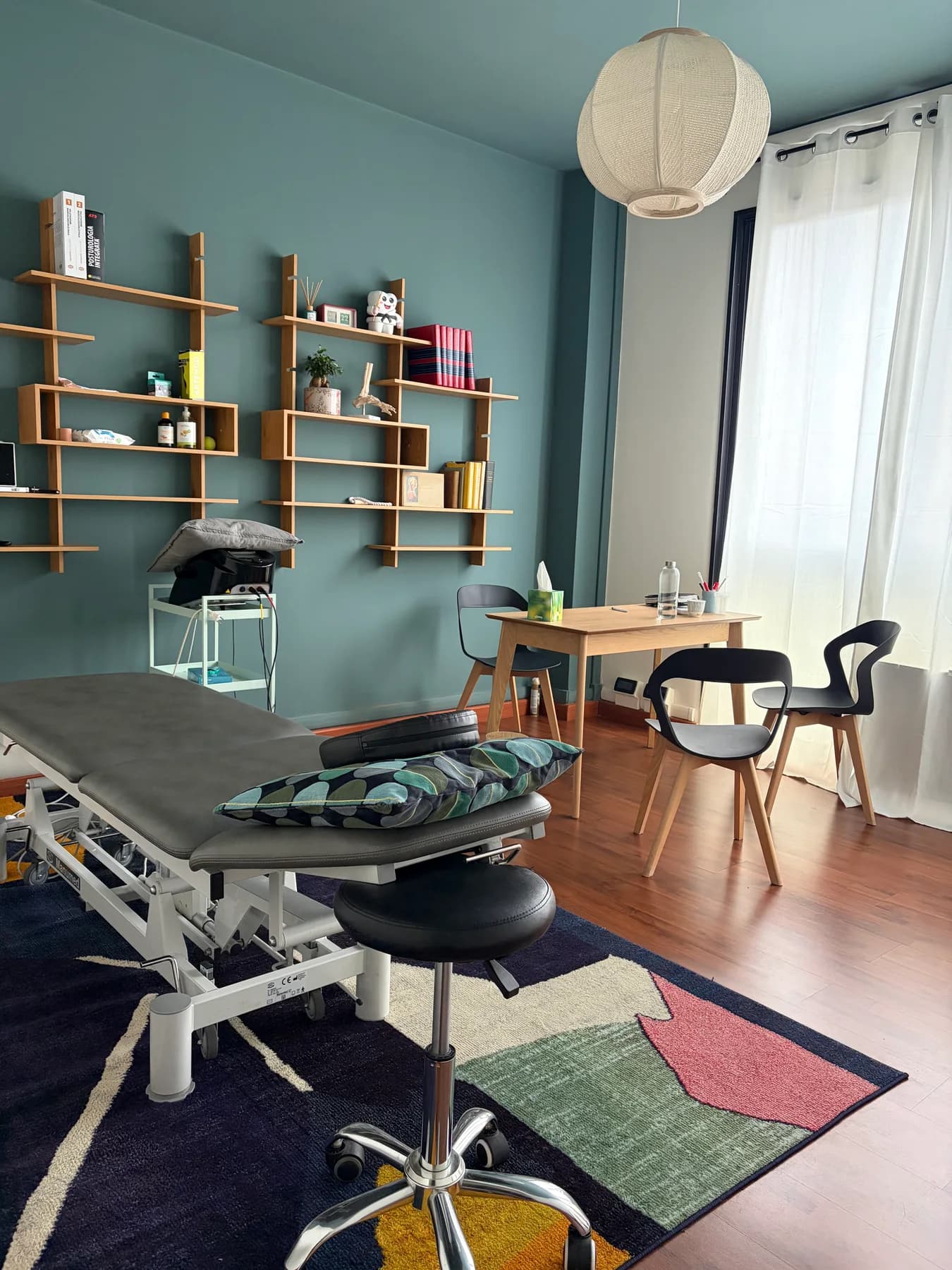 L’ambiente con lettino, mensole e pareti azzurre nello Studio Nidara