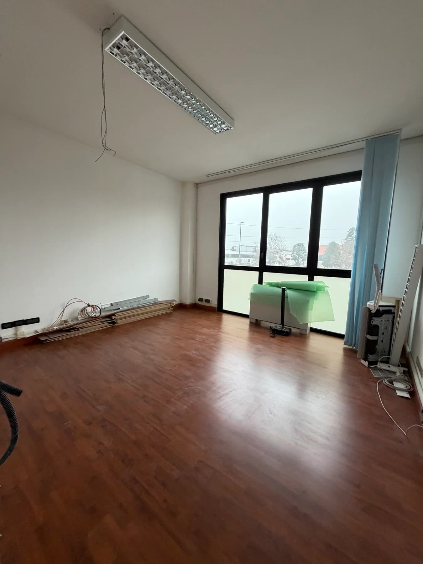 Un ambiente dello studio prima dell’intervento, con pavimento effetto legno