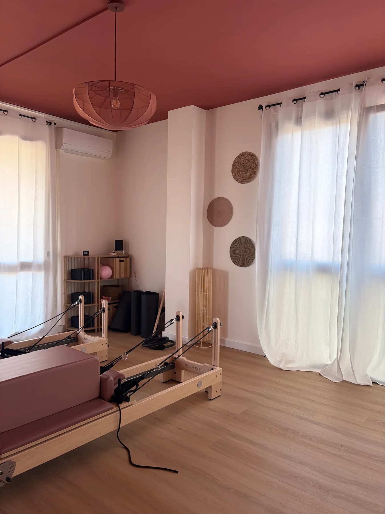 La sala rinnovata con soffitto rosa, tende chiare e attrezzature per l’esercizio